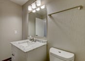 Thumbnail 27 of 31 - A bathroom with a sink, toilet and mirror.