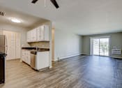 Thumbnail 15 of 31 - A kitchen with white cabinets and a black refrigerator.