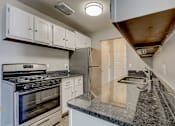 Thumbnail 16 of 31 - A kitchen with a stove, refrigerator, and cabinets.