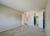 Thumbnail 24 of 31 - A large empty room with carpeted floor and white walls.