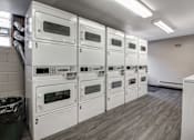 Thumbnail 11 of 27 - A row of white ovens are lined up in a room.