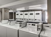 Thumbnail 10 of 27 - A row of white ovens are lined up in a room.