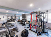 Thumbnail 13 of 43 - A gym with treadmills, elliptical machines, and weightlifting equipment.