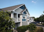 Thumbnail 2 of 44 - A residential building with a blue roof and white walls.
