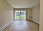 Thumbnail 12 of 21 - an empty living room with a sliding glass door to a yard