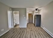 Thumbnail 11 of 21 - an empty living room with a refrigerator and a ceiling fan