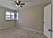 Thumbnail 16 of 21 - an empty bedroom with a ceiling fan and a window