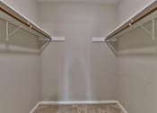 Thumbnail 17 of 21 - a walk in closet with two shelves and two hanging racks on the wall