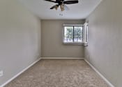 Thumbnail 15 of 21 - an empty bedroom with a window and a ceiling fan