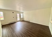 Thumbnail 3 of 10 - A room with a brown floor and white walls.