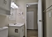 Thumbnail 8 of 21 - a bathroom with a sink and a mirror and a door