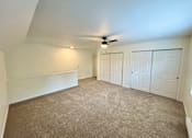Thumbnail 8 of 10 - A room with a carpeted floor and a ceiling fan.