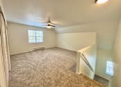 Thumbnail 9 of 10 - A room with a carpeted floor and a window with blinds.