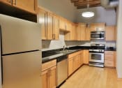 Thumbnail 20 of 35 - a kitchen with wooden cabinets and stainless steel appliances