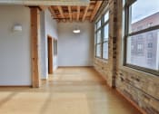 Thumbnail 30 of 35 - a hallway with large windows and wood floors and a ceiling light