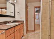 Thumbnail 25 of 35 - a bathroom with a sink and a mirror and a shower