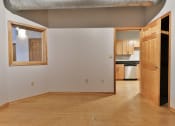 Thumbnail 23 of 35 - an empty living room with a door to a kitchen