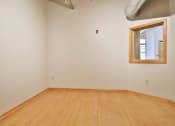 Thumbnail 24 of 35 - an empty room with a wooden floor and a window