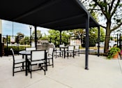 Thumbnail 3 of 93 - A black metal patio with a table and chairs.