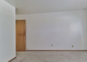 Thumbnail 12 of 33 - A room with a brown door and carpeted floor.