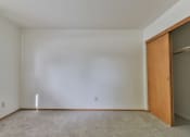 Thumbnail 13 of 33 - A room with a carpeted floor and a wooden door and large closets.
