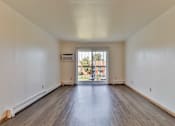 Thumbnail 21 of 33 - the living room of an apartment with wood flooring and a balcony