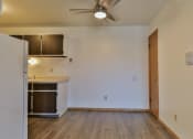 Thumbnail 19 of 33 - an empty living room with a kitchen and a ceiling fan