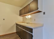Thumbnail 18 of 33 - an empty kitchen with a sink and wooden cabinets