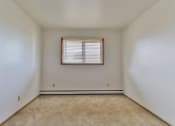 Thumbnail 22 of 33 - A room with a window and carpeted floor.