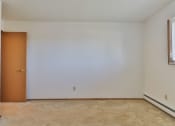 Thumbnail 26 of 33 - A room with a brown door and carpeted floor.