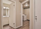 Thumbnail 24 of 43 - a bedroom with a door open to a bathroom with a sink and a mirror
