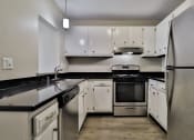 Thumbnail 25 of 43 - an empty kitchen with stainless steel appliances and white cabinets