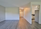 Thumbnail 30 of 43 - an empty living room with wood flooring and a kitchen