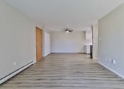 Thumbnail 3 of 15 - an empty living room with wood flooring and a ceiling fan