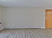Thumbnail 7 of 15 - an empty living room with wood floors and a door