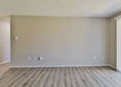 Thumbnail 6 of 15 - an empty living room with wood floors and white walls