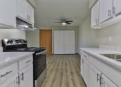 Thumbnail 2 of 15 - an empty kitchen with white cabinets and a ceiling fan