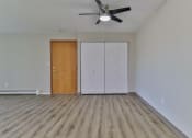 Thumbnail 5 of 15 - an empty living room with wood floors and a ceiling fan