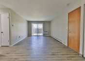 Thumbnail 4 of 15 - an empty living room with wood floors and a door to a balcony