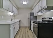 Thumbnail 1 of 15 - the preserve at ballantyne commons apartment kitchen with white cabinets and black appliances