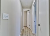 Thumbnail 8 of 15 - a hallway with white walls and wood floors and a white door