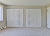 Thumbnail 10 of 15 - an empty room with white closets and a carpeted floor