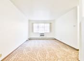Thumbnail 4 of 11 - A room with a carpeted floor and a window with blinds.