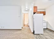 Thumbnail 3 of 11 - A white refrigerator sits in a kitchen next to a white wall.