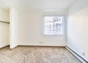 Thumbnail 6 of 11 - A room with a window and carpeted floor.