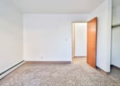 Thumbnail 8 of 11 - A room with a carpeted floor and a door.