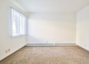 Thumbnail 9 of 11 - A room with a window and a carpeted floor.