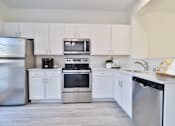 Thumbnail 2 of 102 - A kitchen with white cabinets and stainless steel appliances.