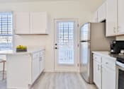 Thumbnail 4 of 102 - A kitchen with white cabinets and a refrigerator.