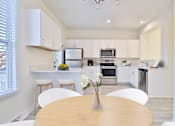 Thumbnail 1 of 102 - A modern kitchen with white cabinets and stainless steel appliances.
